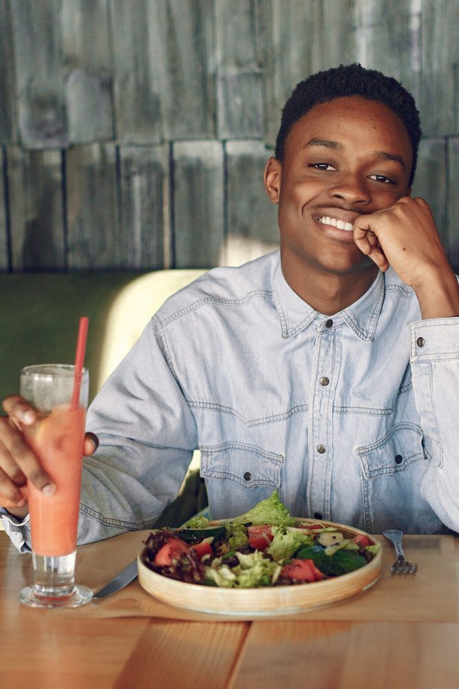 black-man-sitting-cafe-eating-vegetable-salad